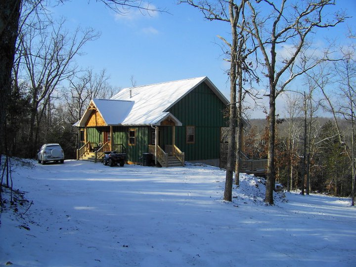 Green house in snowy forest setting