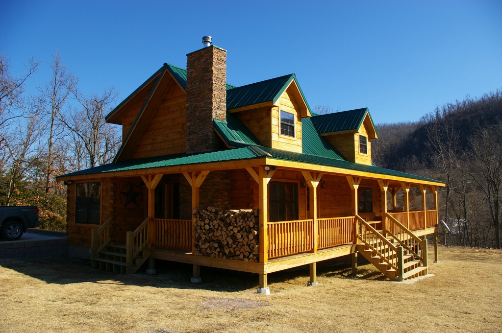 Wooden cabin with green roof in countryside.