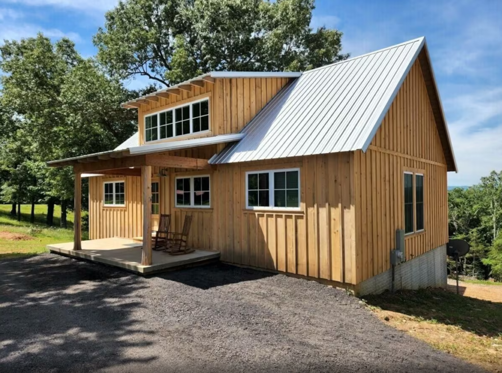 Wooden cabin with metal roof in countryside.