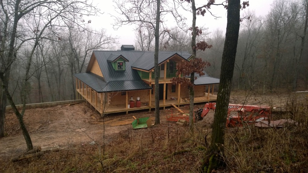 Secluded cabin under construction in wooded area.