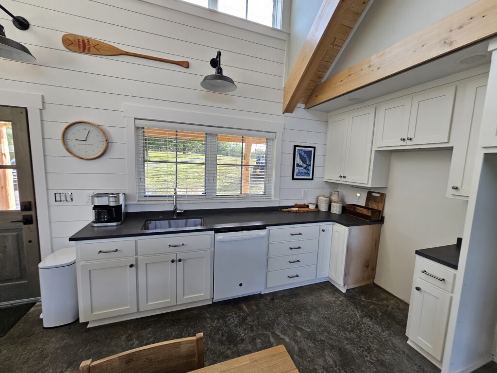 Modern kitchen interior with white cabinets and wooden accents.