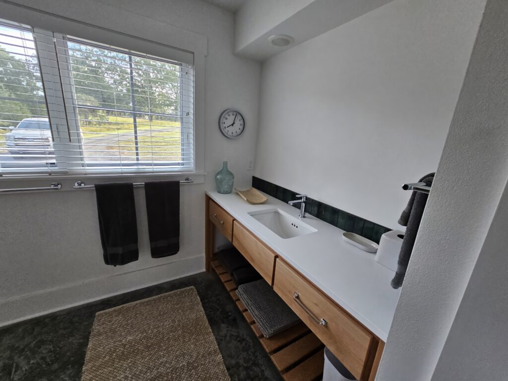 Modern bathroom with natural light and dual sinks.