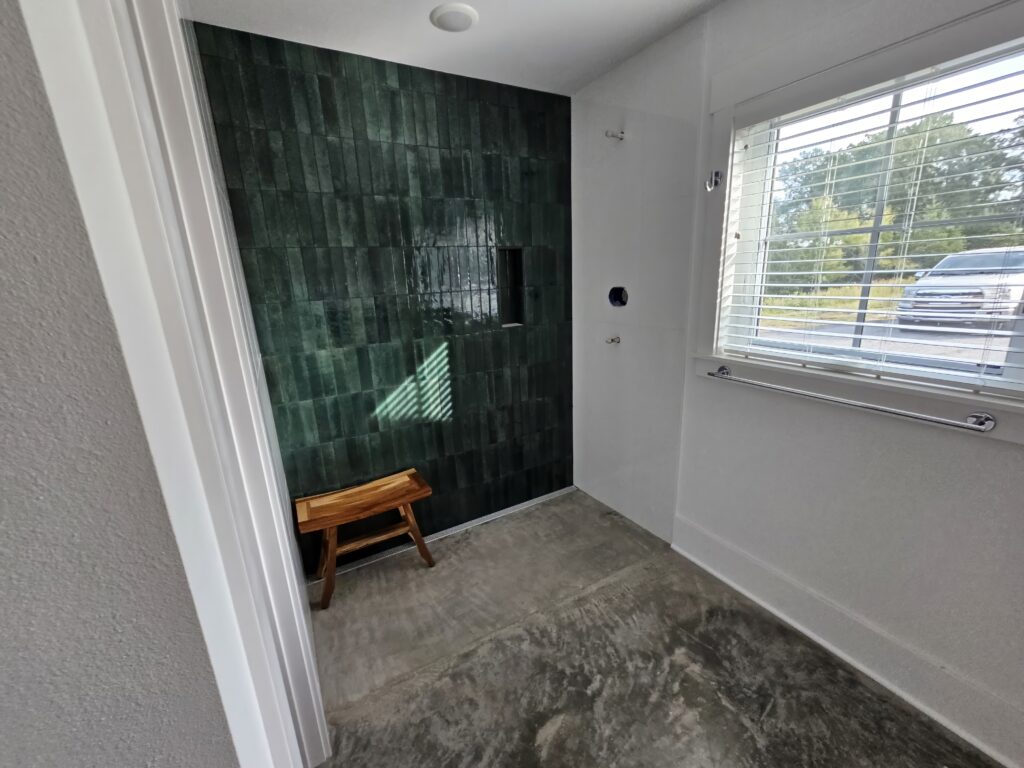 Modern bathroom with green tile design and window.
