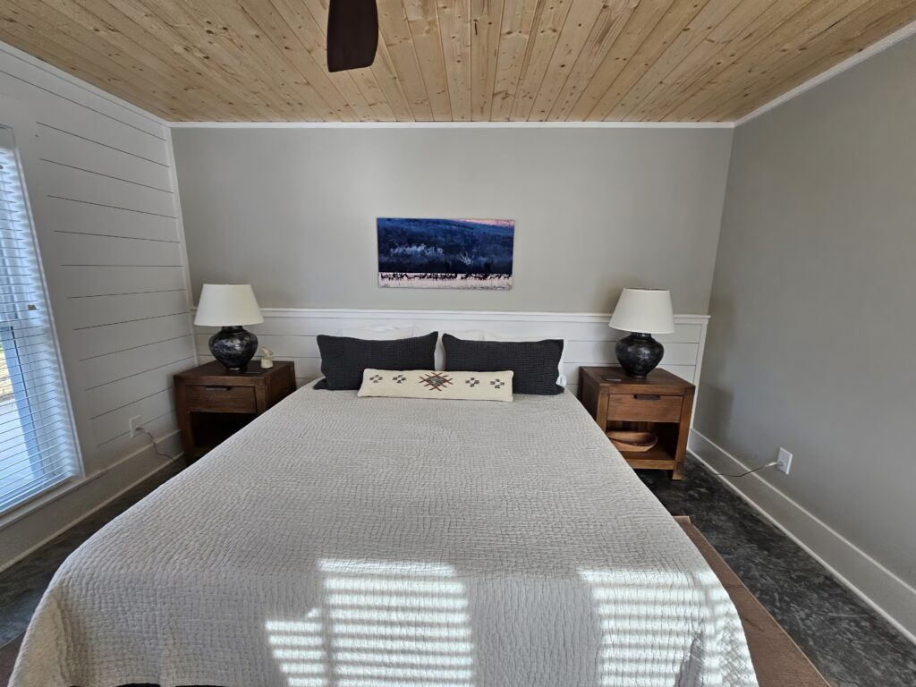 Cozy bedroom with wooden ceiling and elegant decor.