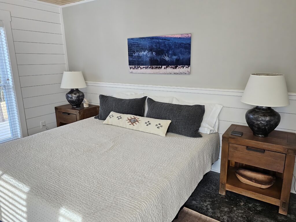 Cozy modern bedroom interior with art and nightstands.