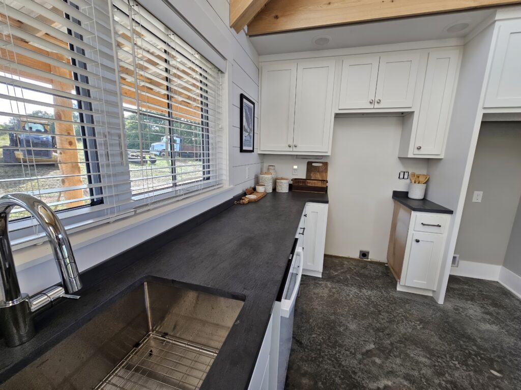 Modern kitchen interior with sink and white cabinets.