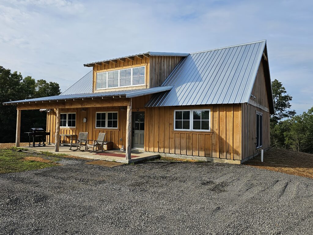 Rustic wooden cabin with blue metal roof.