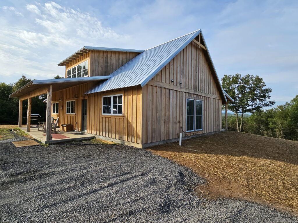 Rustic wooden house with metal roof and scenic view.