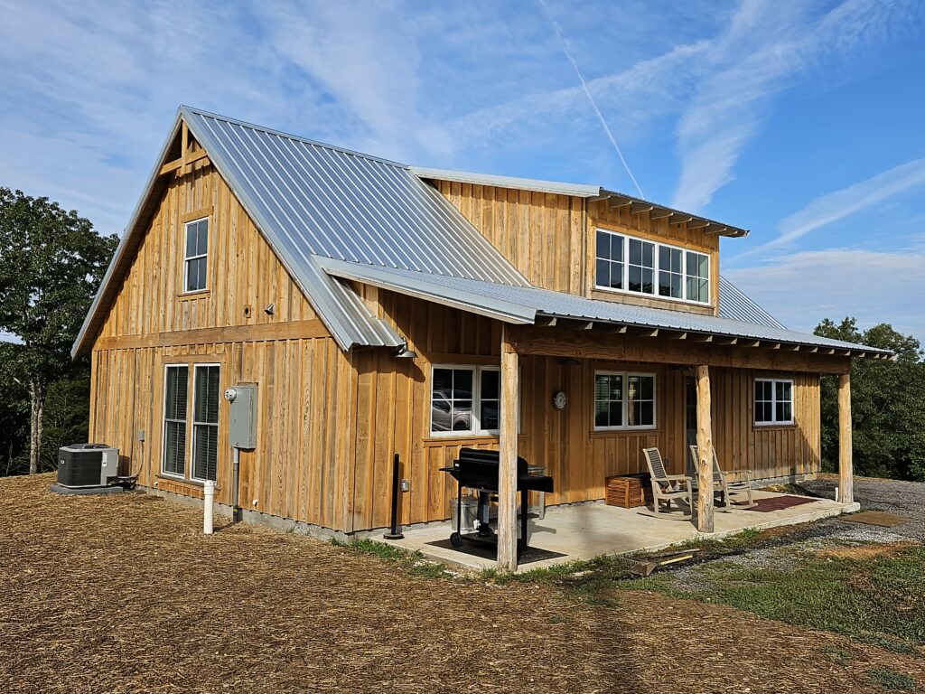 Wooden barn house with metal roof and porch.