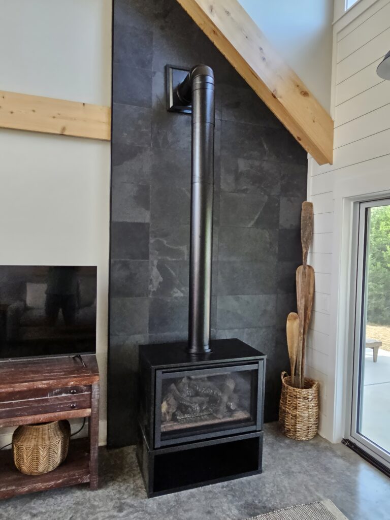 Modern fireplace with metal chimney in stylish interior.