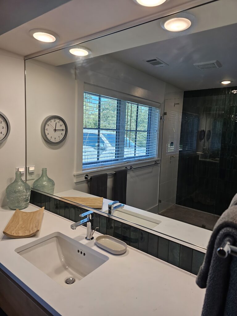 Modern bathroom with tiled shower and natural light.