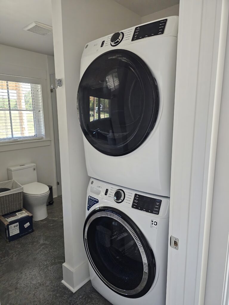 Stacked washer and dryer in laundry room.