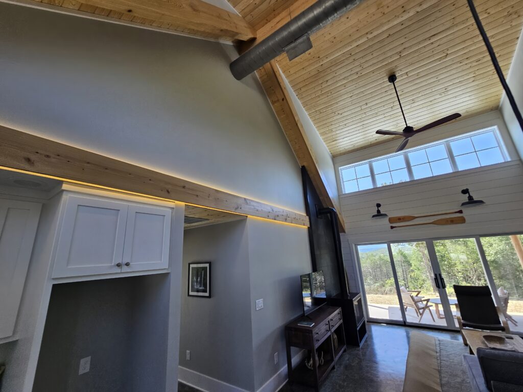 Modern interior, high ceiling, natural light, wooden beams.