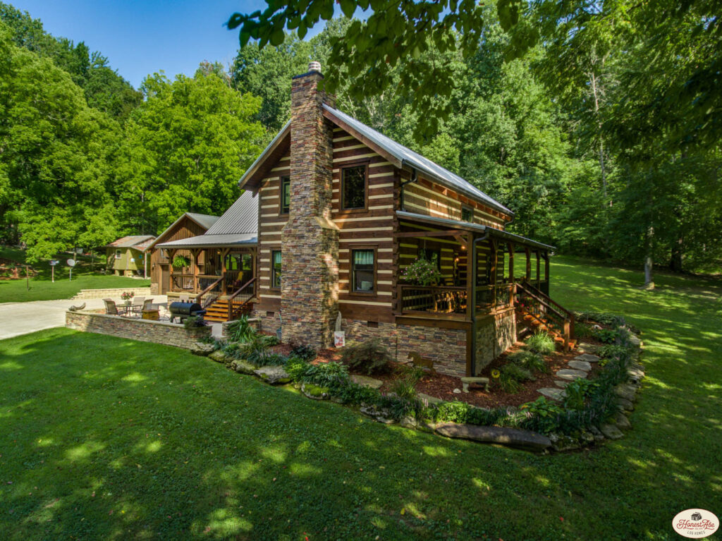 Rustic log cabin home surrounded by lush greenery.