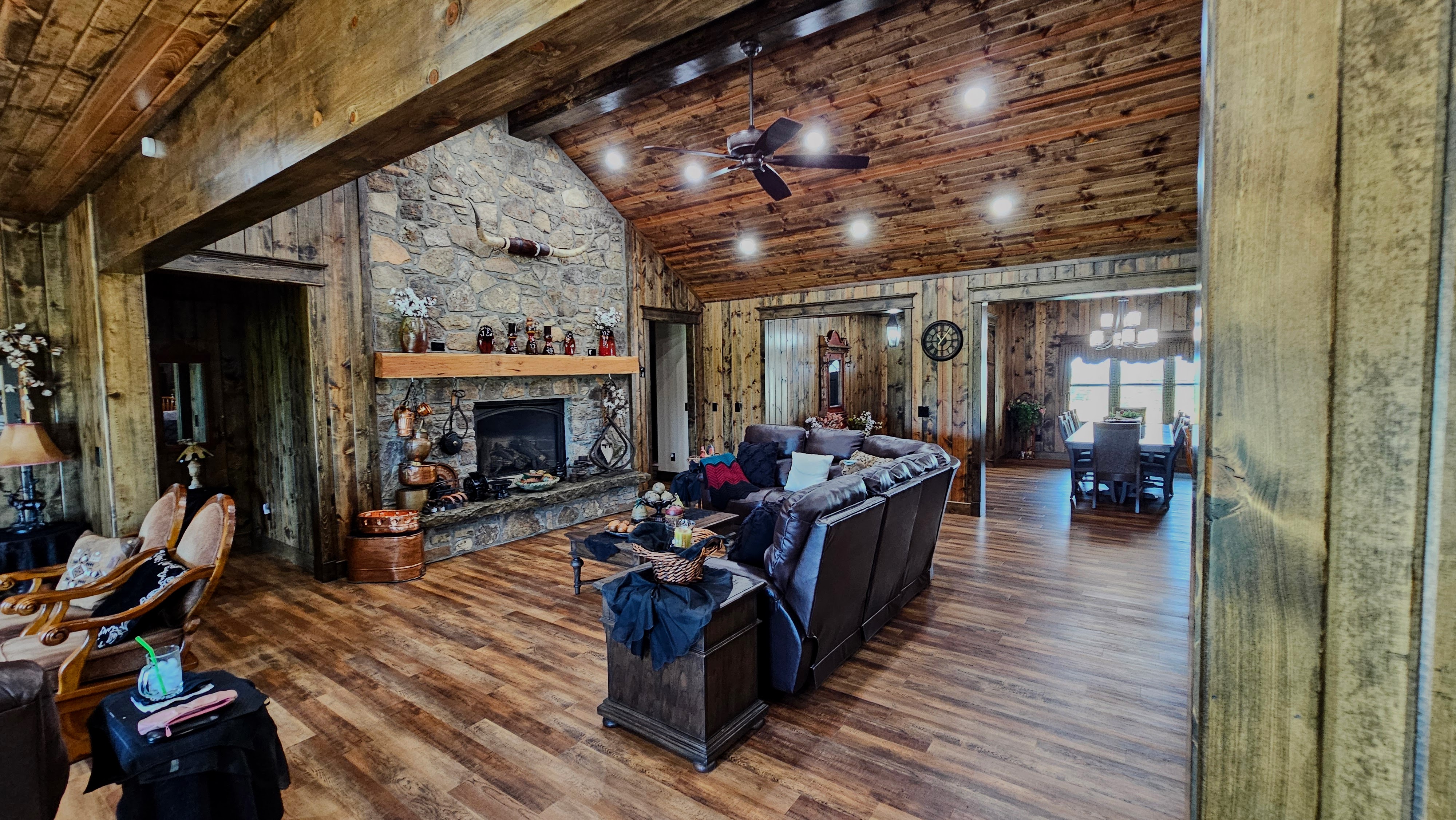 Wooden cabin with garage in forested mountain area.