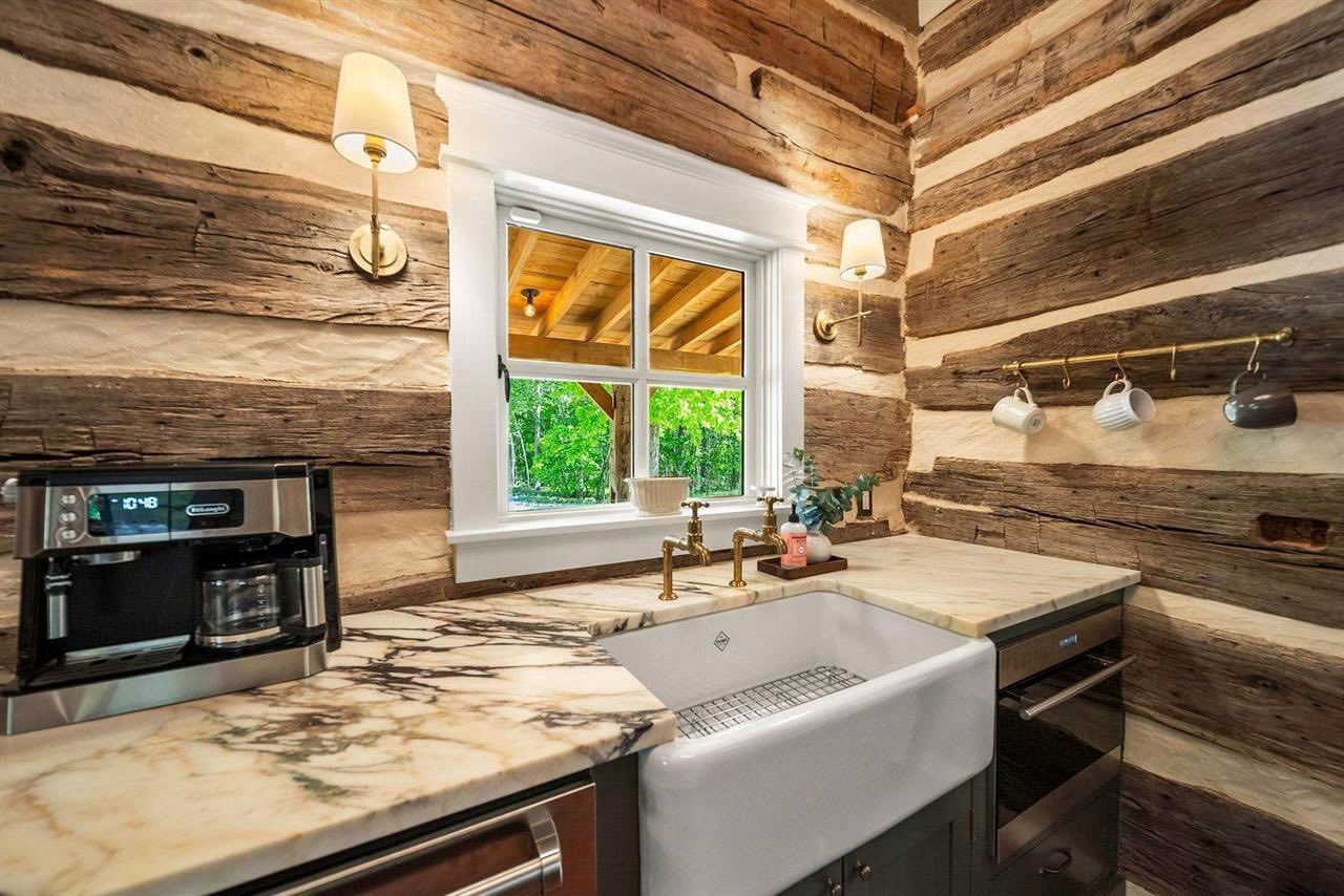 Close view of marble counters, log walls, and fine finish work inside the cabin
