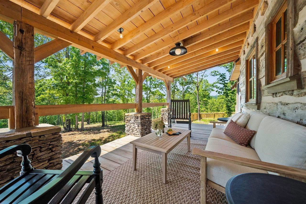 Covered porch sitting area overlooking the wooded property