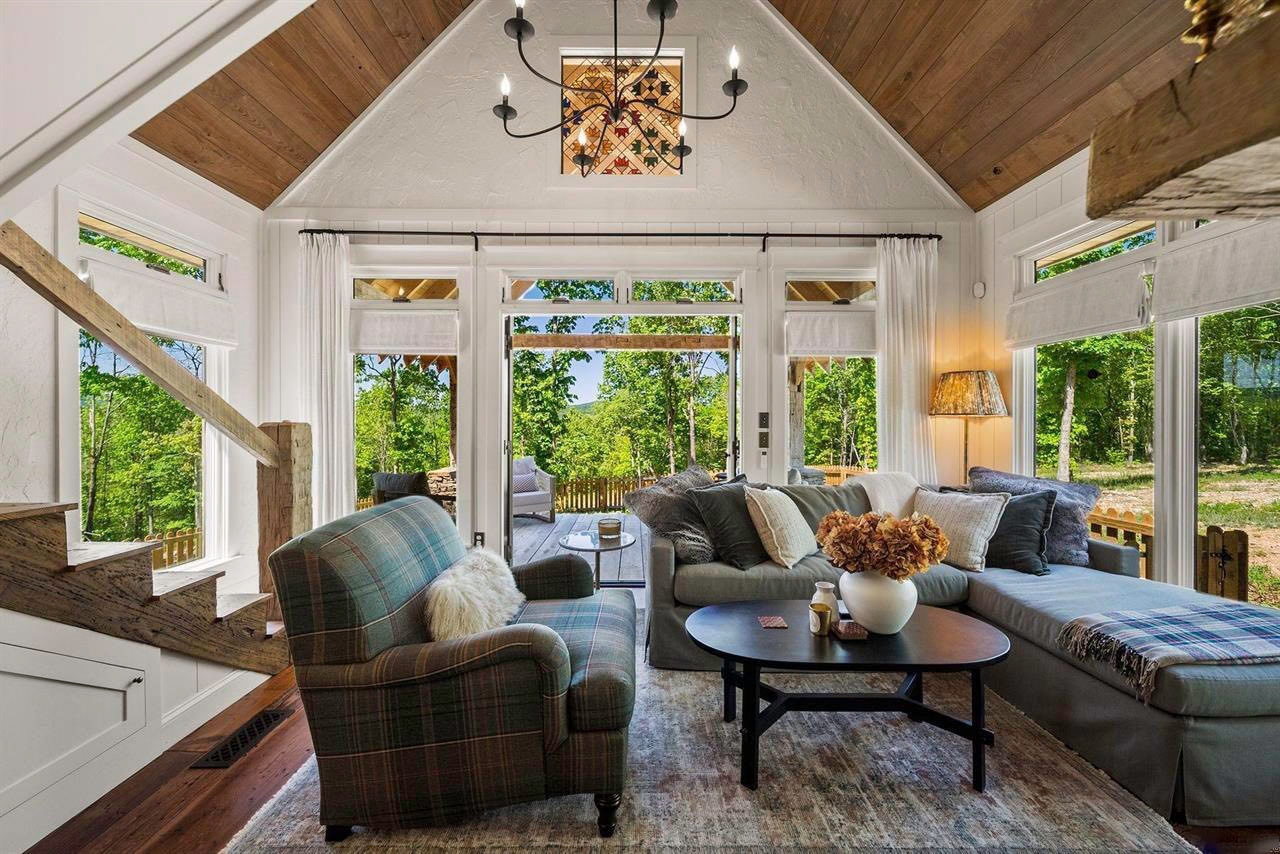 Light-filled living room with wood ceiling, large windows, and leather seating