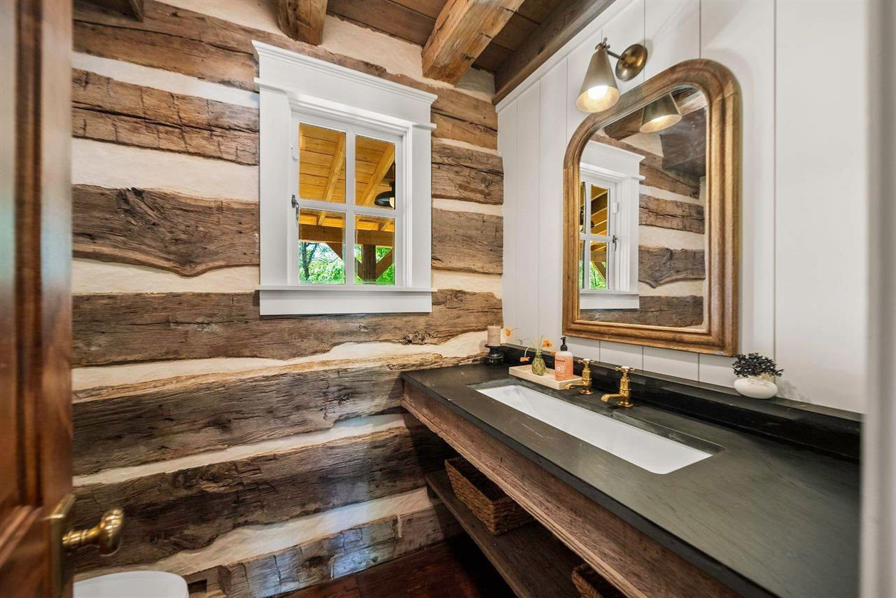 Bathroom vanity with natural soapstone and log wall detail